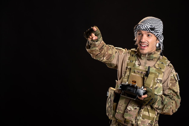 Soldato palestinese che usa il telecomando sul muro nero