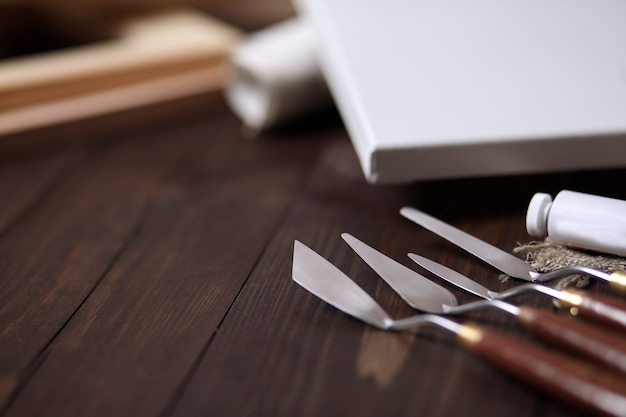 Paletmessen en wit leeg canvas op een bruine houten tafel