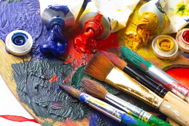 A palette of paint and brushes with a paint brush on it.