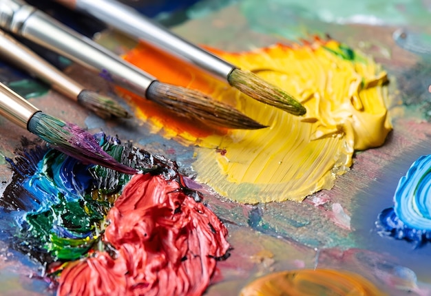A palette with paint on it and a paintbrush with the word artist on it.