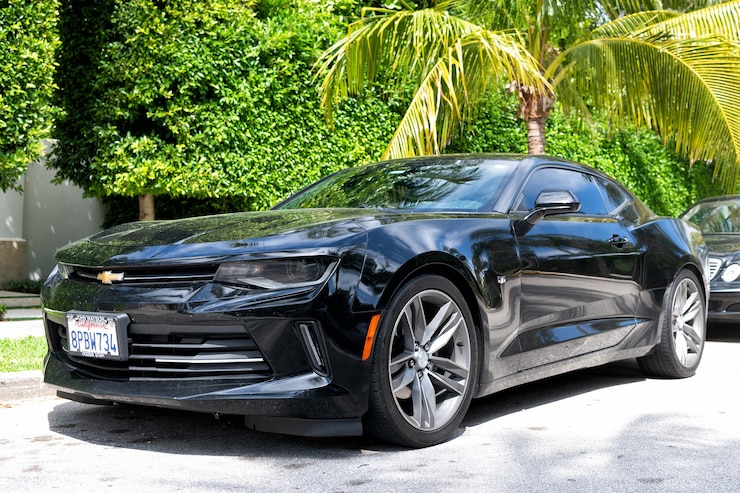 फोटो palm beach, florida usa - march 21, 2021: black chevrolet camaro luxury car parked in palm beach, united states of america. low corner view.
