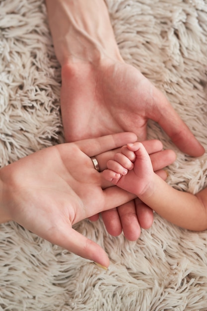 Photo palm newborn baby on a light