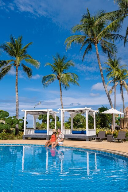 Palm trees by swimming pool against blue sky