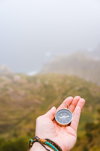 Palm with compass Concept of figure out right direction Haze valley and mountains in background