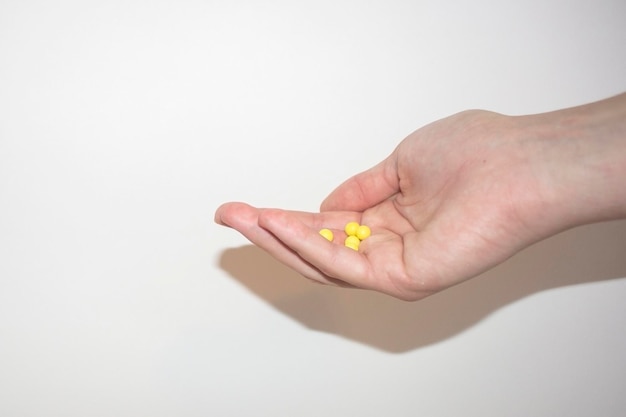 건강 관리를 위한 작고 밝은 비타민 알약이 있는 팜