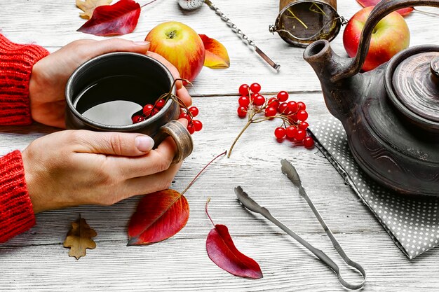 Palm of your hand with cup of autumn tea