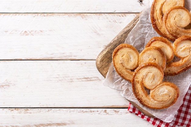 Palmier puff pastry in plate on wooden table