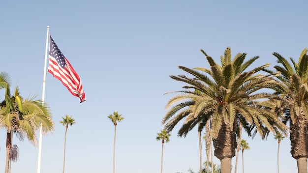 Palms and american flag los angeles california usa summertime aesthetic of santa monica and venice beach starspangled banner stars and stripes atmosphere of patriotism in hollywood old glory