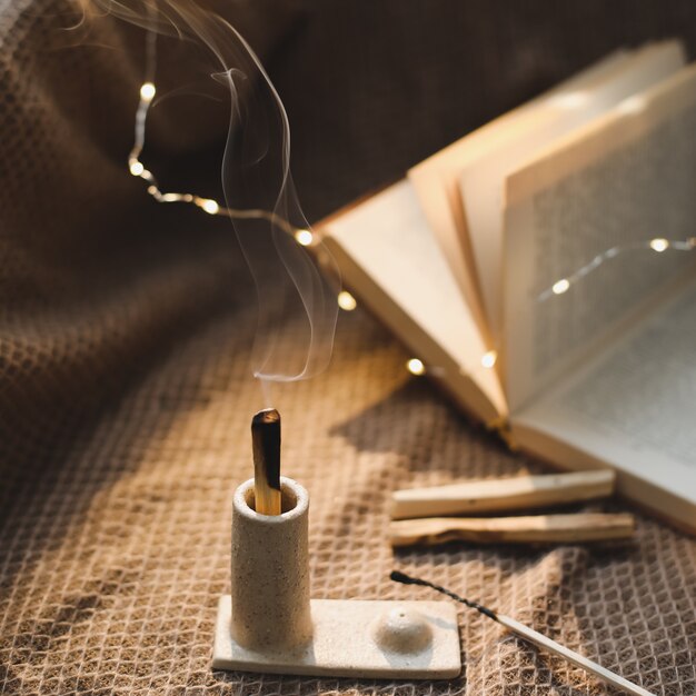 Palo Santo houten stok in vuur en vlam met rook in een mooie kandelaar