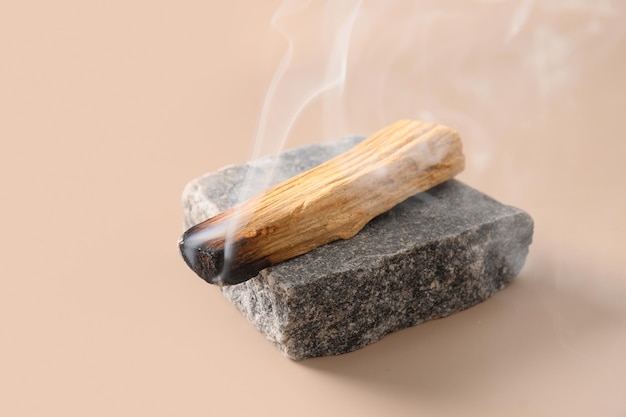 palo santo stick incense burning on stone