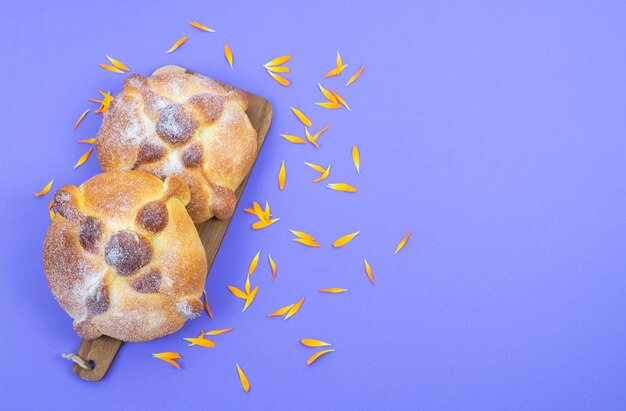 파란색 배경에 Pan de muerto, 전형적인 멕시코 음식. 죽은 축하의 날. 공간을 복사합니다. 평면도.