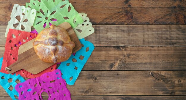 Pan de muerto on wooden background, typical mexican food. Day of the dead celebration. Copy space. Top view.