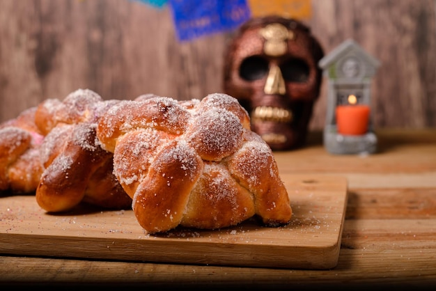 Pan de muertos en geschilderde schedel op houten tafel. Typisch dessert van de viering van de Dag van de Doden