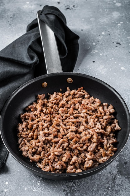 Pan fried minced meat to Italian pasta Gray background Top view