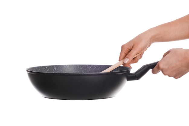 A pan in hands on a white wall