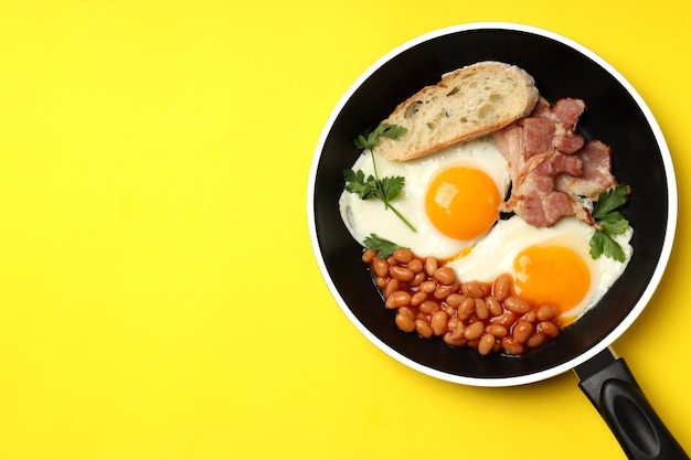 Pan met smakelijk ontbijt op gele achtergrond