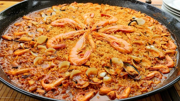 Photo a pan of paella with shrimps and mushrooms