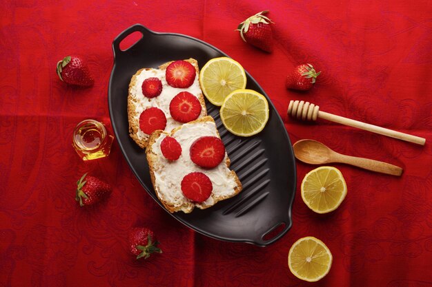 A pan with food on it and a spoon on the table with a red cloth.