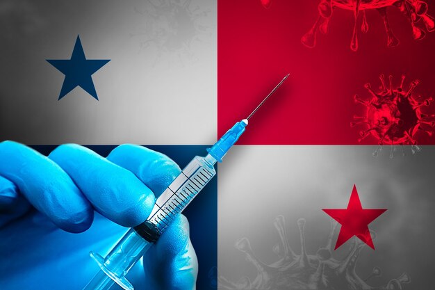 Panama Covid19 Vaccination Campaign Hand in a blue rubber glove holds syringe in front of flag