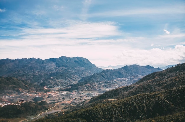 Panaromic and beautiful view of houses and green terrace rice fields with blue sky and clouds at the village in Sapa Vietnam