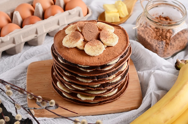 Pancake cake. A stack of chocolate pancakes with chocolate cream and almonds on top.