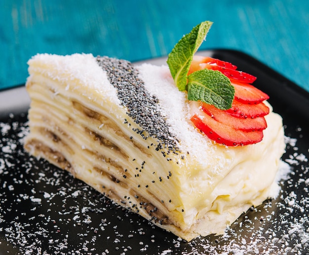 Фото Блинный торт с кусочками клубники, кокоса и мака и сметаной