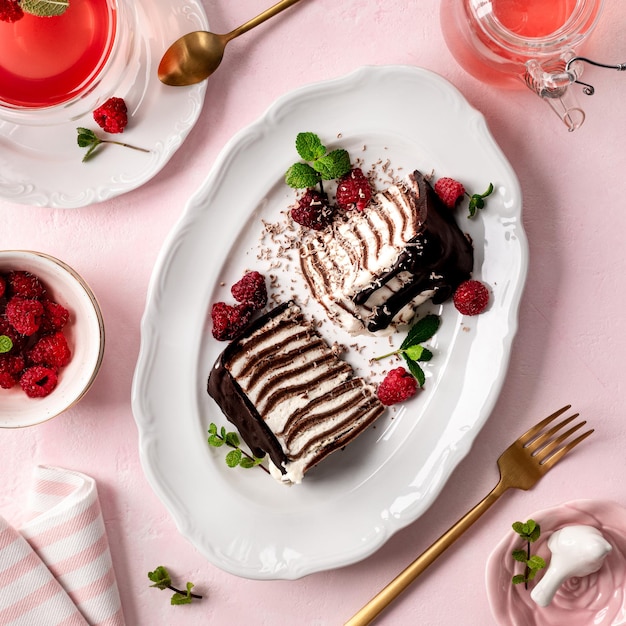 Pancake chocolate cake with fresh raspberries on a pink background