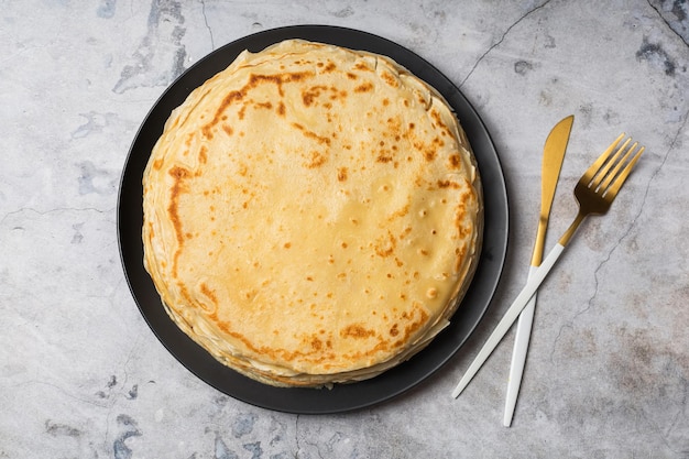 Foto pancake sul piatto isolato su priorità bassa bianca. mucchio di frittelle sottili in stile russo per le vacanze maslenitsa. sfondo di cibo per colazione e carnevale.