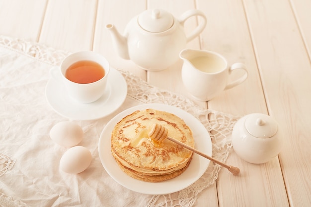 Pancake week:  pancakes with honey and tea on the table