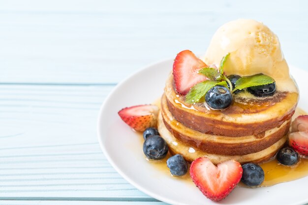 ブルーベリー、イチゴ、蜂蜜、バニラアイスクリームのパンケーキ