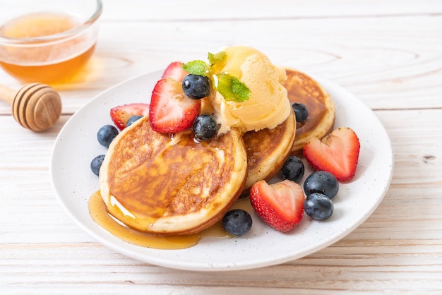 pancake with blueberries, strawberries, honey and vanilla ice-cream