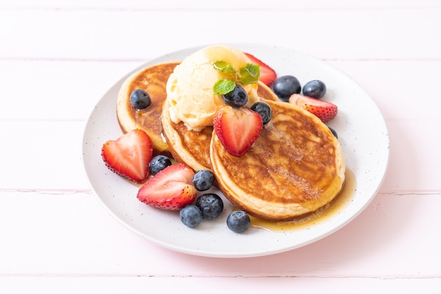 pancake with blueberries, strawberries, honey and vanilla ice-cream