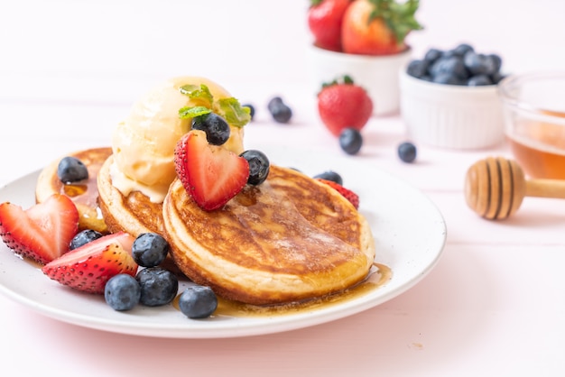 pancake with blueberries, strawberries, honey and vanilla ice-cream