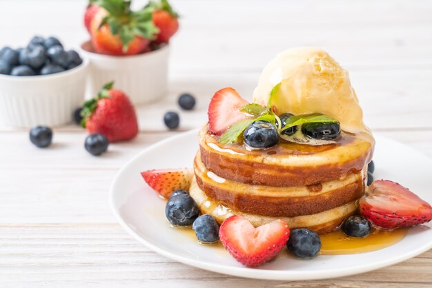 pancake with blueberries, strawberries, honey and vanilla ice-cream