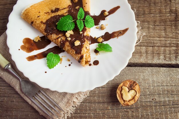 Pancake with chocolate and nuts in the form of a heart. Food con