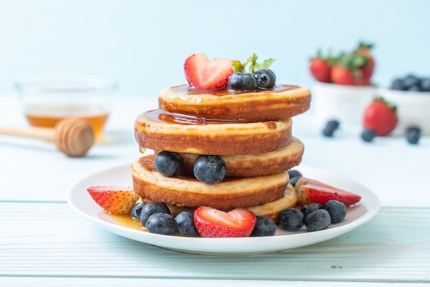 pancake with fresh blueberries, fresh strawberries and honey