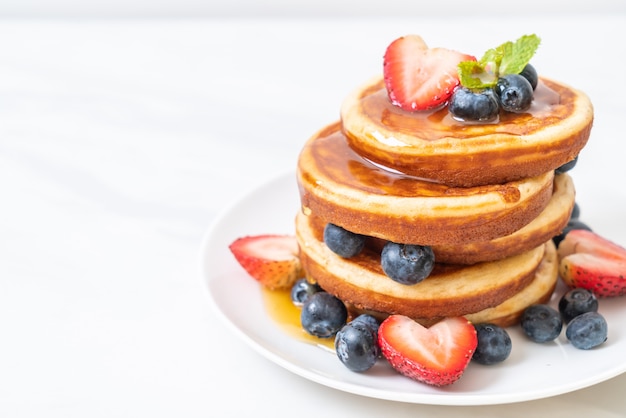 pancake with fresh blueberries, fresh strawberries and honey