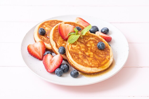 pancake with fresh blueberries, fresh strawberries and honey