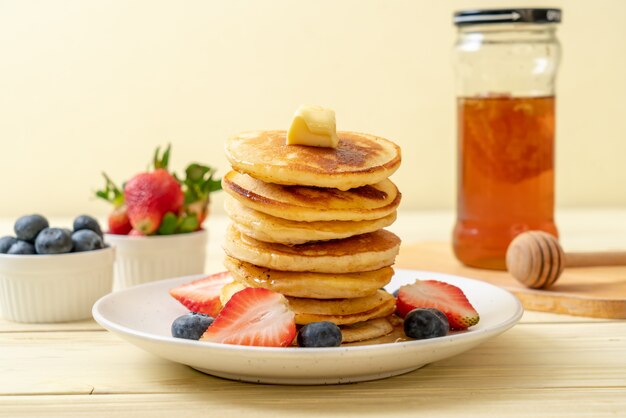 Pancake with strawberries, blueberries and honey