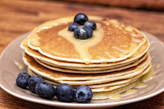 Pancakes on the brown wooden background