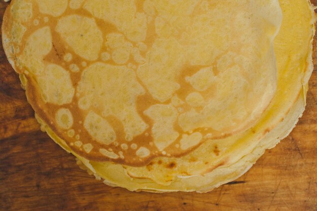 I pancake si chiudono. frittelle su fondo di legno. una pila di frittelle su un supporto di legno.