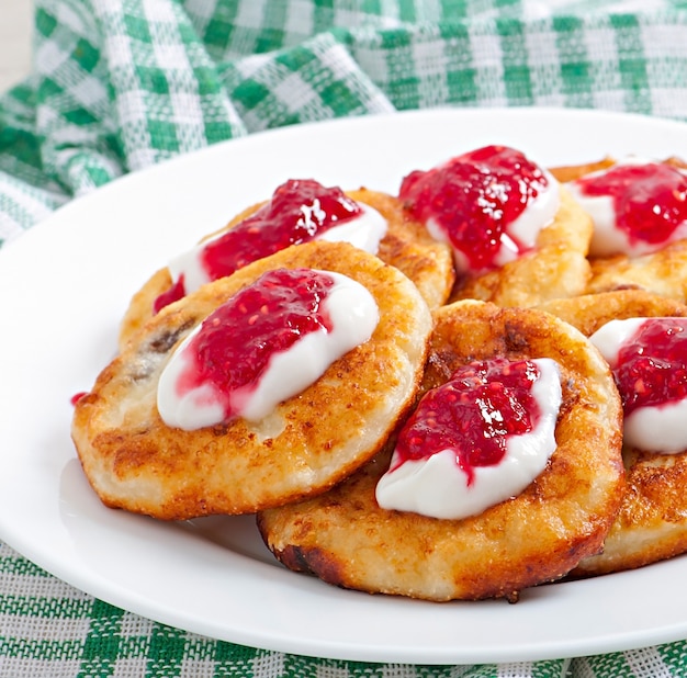 Pancakes of cottage cheese with sour cream and raspberry jam