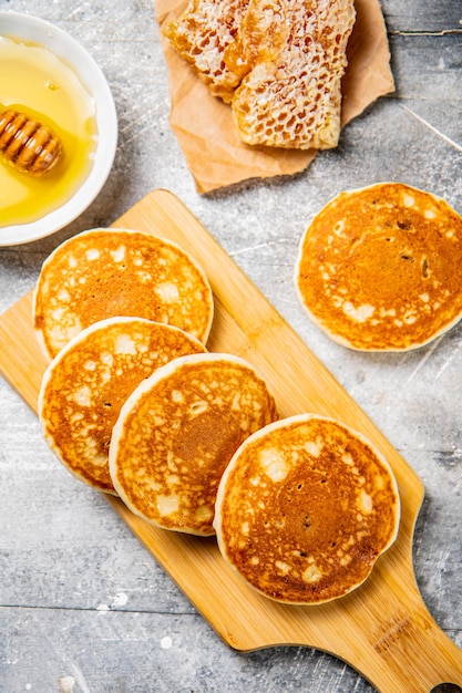Pancakes on a cutting board with honey