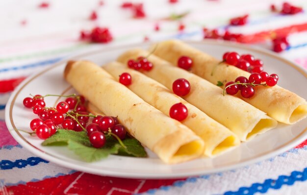 Pancakes decorated with red currant berries.