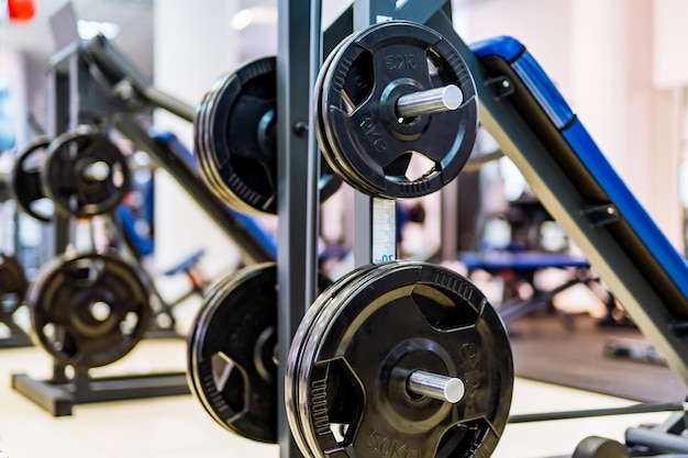 Pancakes on a dumbbell in a gym Sport and healthy life concept Set of pancakes on gym background Sport equipment closeup