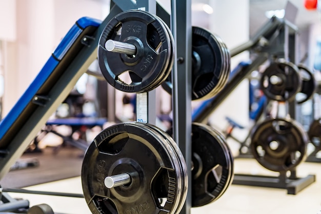 Photo pancakes on a dumbbell in a gym. sport and healthy life concept. set of pancakes on gym background. sport equipment closeup.