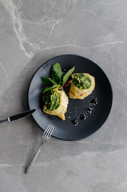 Pancakes filled with spinach Healthy breakfast on grey background Copy space