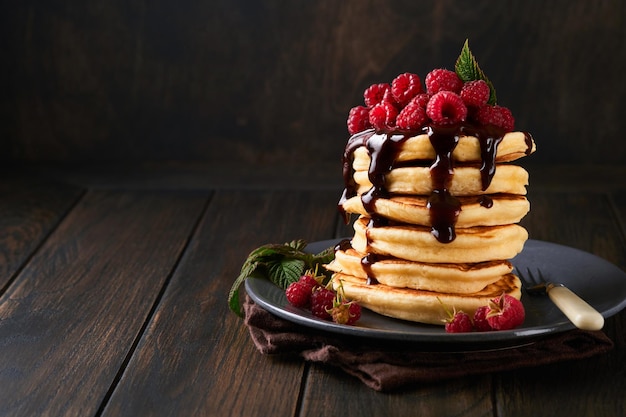 pancakes pancakes with fresh raspberry with chocolate glaze or toppings in gray bowl on old wooden table background homemade classic american pancakes page for magazine concept
