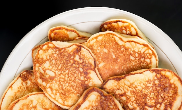 Photo pancakes in a plate on a black background