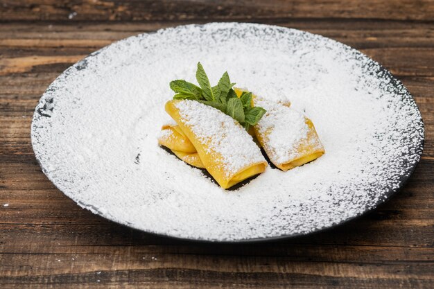 Pancakes in plate on a wooden surface